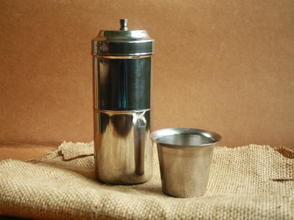 A clear close up shot of aesthetic South Indian Coffee Filter and the steel glass has been kept
