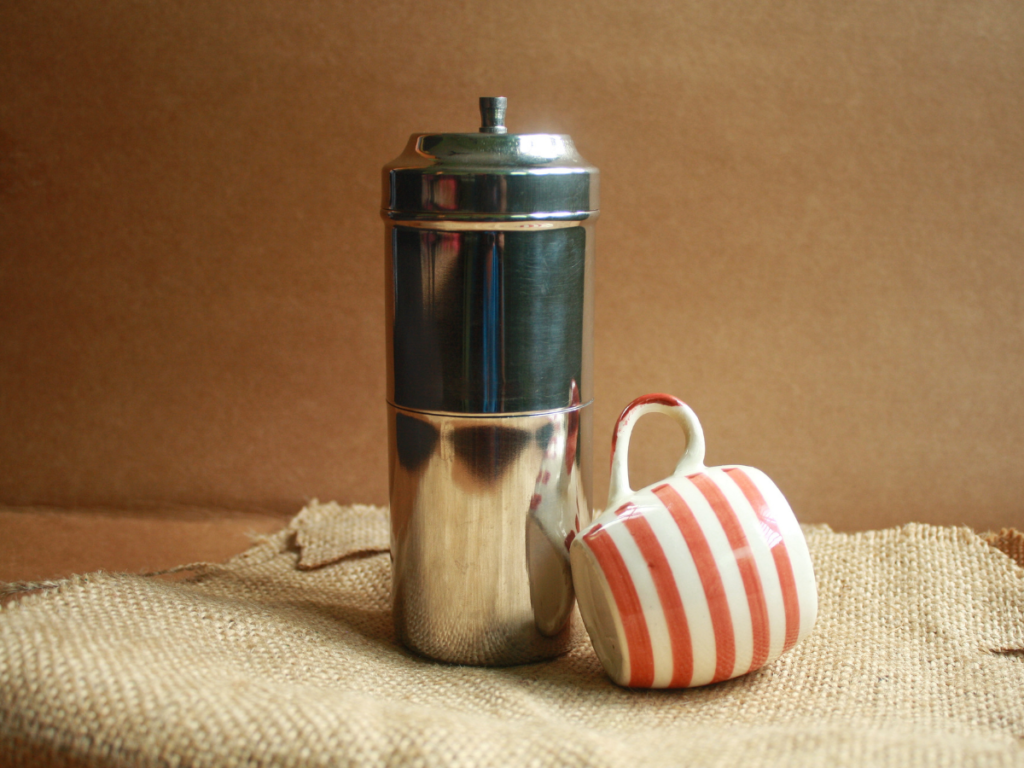 Traditional South Indian coffee filter with fresh decoction dripping into lower chamber
